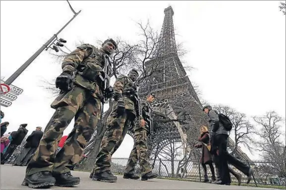  ?? GONZALO FUENTES / REUTERS ?? Tres soldados franceses patrullan junto a la torre Eiffel, en la capital francesa