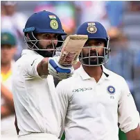  ?? Reuters ?? Virat Kohli raises his bat after scoring his half century as Ajinkya Rahane looks on during the second day’s play. —