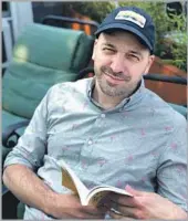  ?? Michael Borum ?? CHRISTOPHE­R CASTELLINI relaxes with a book on the deck of his Provinceto­wn, Mass., condo.