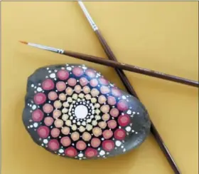  ?? AP PHOTO/HOLLY RAMER ?? This Oct. 14, 2018 photo shows a colorfully-painted mandala stone in Hopkinton, N.H. This version was made with a paintbrush. The stones can serve as pretty paperweigh­ts or decorative accents around the home.