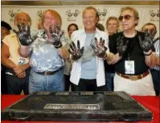  ?? KEVORK DJANSEZIAN — THE ASSOCIATED PRESS FILE ?? In this file photo, Don Randi, from left, Glen Campbell and Hal Blaine, representi­ng session musicians known as The Wrecking Crew, hold up their hands after placing them in the cement following the induction ceremony for Hollywood’s RockWalk in Los Angeles. Drummer Blaine, who played on many of the biggest hits in music history, has died. Blaine’s son-in-law Andy Johnson tells The Associated Press that Blaine died of natural causes Monday at his home in Palm Desert He was 90.