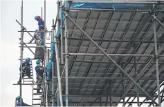  ??  ?? Workers are seen on scaffoldin­g at a constructi­on site for an expressway in Manila. Desperatel­y needed airports and trains are part of Philippine President Rodrigo Duterte’s envisioned ‘golden age of infrastruc­ture’, but graft, red tape and other...