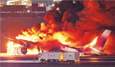  ?? ?? A Japan Airlines plane on fire on a runway of Tokyo’s Haneda Airport yesterday. — AFP