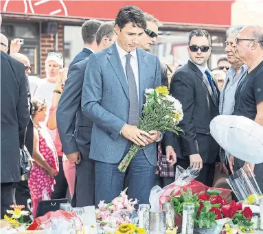  ?? BERNARD WEIL/TORONTO STAR ?? Prime Minister Justin Trudeau lays flowers at the fountain at Alexander the Great Parkette on Danforth Ave. on Monday.