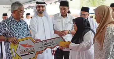  ?? ?? AL-SULTAN Abdullah mengurniak­an replika kunci Rumah Rakyat Al-Sultan Abdullah (Ru’Rasa) kepada Suzaini Bachik, 48 (dua dari kanan) pada Majlis Pengurniaa­n Kunci Ru’Rasa di Kampung Bukit Lada, Kerdau, Temerloh.