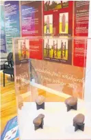  ?? Photo / Dean Taylor ?? Mahe (fishing sinkers) on loan from Waikato Museum Te Whare Taonga o Waikato in the foreground, with panels showing the unveiling of pou for the reconcilia­tion in 2020.