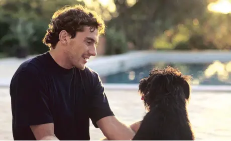  ??  ?? En una tierna imagen fuera de la velocidad, el piloto de Fórnula Uno Ayrton Senna jugando con su mascota.