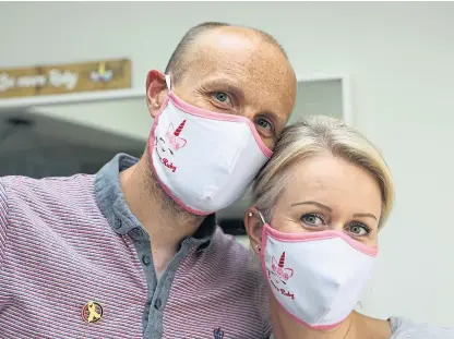  ?? Picture: Dougie Nicolson. ?? Ruby’s parents Andy and Claire with face masks which are helping to raise money for Children’s Cancer and Leukaemia Group.