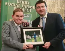  ??  ?? Minister of State at the Department of Transport, Tourism and Sport Brendan Griffin presents Tim Heffernan with a framed photo of his work on The Kerry Social Farming Project.