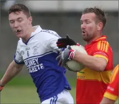  ??  ?? Horeswood captain P.J. Banville has his space closed down by Conor Byrne of Ballyhogue.