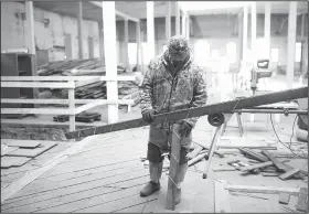  ?? NWA Democrat-Gazette/CHARLIE KAIJO ?? Hugo Rodriguez of Wilson Flooring measures wood panels for flooring Thursday at the old Dollar Saver building in Rogers. Northwest Arkansas restaurant, coffee, bakery and other owners as well as Realtors and architect firms have partnered to restore...