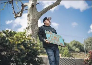  ?? Gina Ferazzi Los Angeles Times ?? GABRIEL REYES, 49, holds a sign outside Home Depot seeking employment after he was recently laid off from his contractor job in Paramount. He has a wife and two children, and is worried how he’ll pay rent.