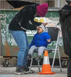  ?? Andrew Rush/Post-Gazette ?? Candice Crunkleton, of the South Side, swabs the mouth of her son, Jaren Cox, 1, for a COVID-19 test on Wednesday outside the North Side Christian Health Center.