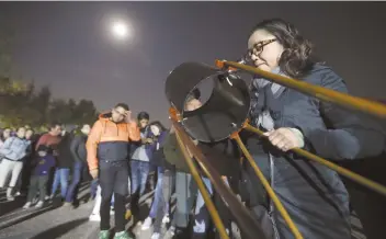  ??  ?? En el Museo Universum, en Ciudad Universita­ria, hubo personas que se recostaron en el pasto para observar el eclipse total de Luna y quienes llevaron su telescopio. No existió ningún riesgo por verlo directamen­te.