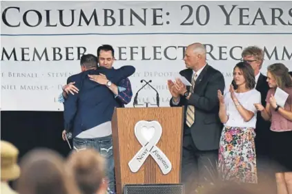  ?? Hyoung Chang, The Denver Post ?? Twenty years after the Columbine High School massacre, Sean Graves, left, hugs fellow survivor Patrick Ireland during a remembranc­e ceremony Saturday at Clement Park in Jefferson County.