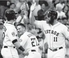  ??  ?? Astros teammates greet Evan Gattis (11) after his three-run homer in the third inning. Orioles starter Mike Wright, who had allowed just three runs over his first three starts, yielded five runs in the inning.