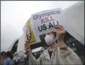  ?? Associated Press ?? DIVIDED
A person protests against the Olympic Games near Komazawa Olympic Park, during the unveiling ceremony for the Olympic Flame on Friday in Tokyo.