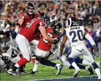  ?? SEAN M. HAFFEY / GETTY IMAGES ?? Atlanta running back Devonta Freeman (center) scores a touchdown as the Falcons spoil the Rams’ first playoff game at the Los Angeles Coliseum since 1979, winning 26-13.