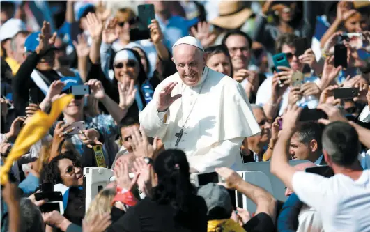  ??  ?? Le pape François salue les milliers de fidèles rassemblés devant la basique Saint-pierre pour la cérémonie de canonisati­on.