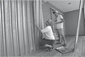  ?? ERIC HASERT/USA TODAY NETWORK VIA TCPALM ?? Barry Kowalik of Danville, Ky., helps his father Frank Kowalik board up his home Thursday in the Fairlane Harbor neighborho­od of Vero Beach, Fla., in preparatio­n for the arrival of Hurricane Dorian.