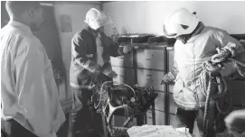  ??  ?? Firefighte­rs examine a photocopie­r which was burnt in an office at Tredgold Building which houses the Bulawayo magistrate­s’ courts yesterday