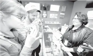  ?? AGENCE FRANCE PRESSE ?? Tourists Laura Torgerson and Ryan Sheehan, visiting from Arizona, smell cannabis buds at the Green Pearl Organics dispensary on the first day of legal recreation­al marijuana sales in California, in Desert Hot Springs, California.