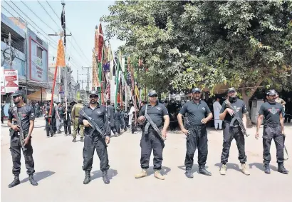  ?? — APP ?? Security officials stand alert along the route of a Muharram procession in Multan on thursday.