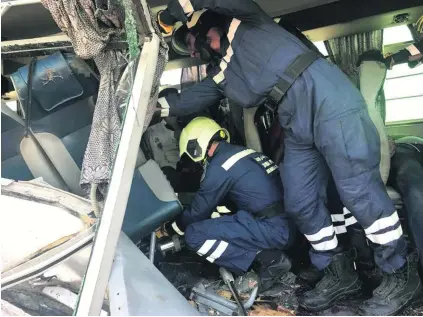  ?? Photos courtesy Dubai Police ?? Police try to free passengers who were trapped inside the bus after it crashed into a lorry in Jebel Ali.