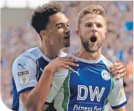  ??  ?? Michael Jacobs (right) celebrates with Antonee Robinson after scoring Wigan’s first