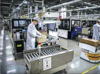  ?? PROVIDED TO CHINA DAILY ?? An employee packs smartphone­s at a production line of Huawei in Dongguan, Guangdong province.