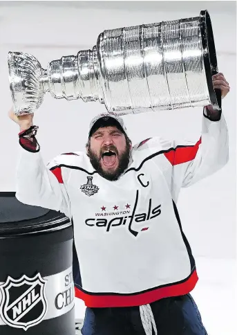  ?? ETHAN MILLER/GETTY IMAGES ?? Washington captain Alex Ovechkin hoists the Stanley Cup high above his head on Thursday night in Las Vegas after leading his team to a 4-3 victory in Game 5 to clinch the series. The Capitals’ captain was named the Conn Smythe Trophy winner.