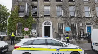  ?? Photo Domnick Walsh ?? Gardaí protect the scene at Finnegans Hostel on Denny Street the first floor of which was badly damaged by an early morning fire last Wednesday.