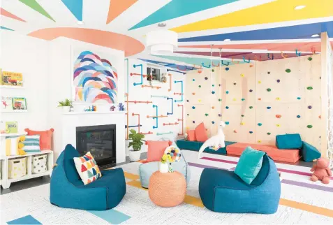  ?? LAURA METZLER ?? A ceiling painted with a mural and colorful monkey bars brighten up this space by grOH! Playrooms.