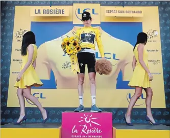  ?? ASSOCIATED PRESS FILE PHOTO ?? Britain’s Geraint Thomas celebrates after the 11th stage of the Tour de France as so-called “podium girls” leave the platform. The role of the girls has been called into question.