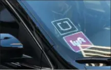  ?? RICHARD VOGEL - ASSOCIATED PRESS FILE PHOTO ?? In this Jan. 12, 2016 file photo, a ride share car displays Lyft and Uber stickers on its front windshield in downtown Los Angeles.