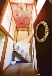  ??  ?? Asian umbrella light fixtures lend a dramatic touch to the vertically oriented foyer.