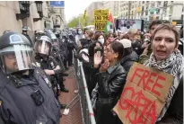  ?? MARY ALTAFFER / AP ?? Police in Riot gear stand guard as demonstrat­ors chant slogans outside the Columbia University campus on April 18 in New York. Protests at Columbia and other colleges over the Israel-gaza war has provided a challenge for President Joe Biden.