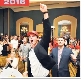  ?? AP PHOTOS ?? Brett Burton (centre) and other supporters of Donald Trump cheer while watching Florida election returns last night at the Hyatt Riverfront in Jacksonvil­le, Florida.