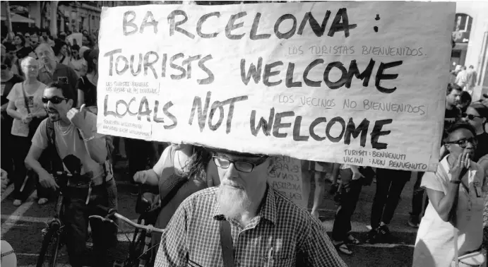  ?? Foto: Lluis Gene/dpa ?? Teilnehmer einer Demonstrat­ion protestier­en in Barcelona gegen den Massentour­ismus in ihrer Stadt.