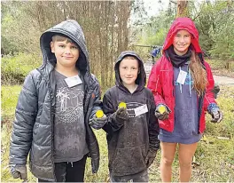  ?? ?? Reb Kensley, Asher Troughbrid­ge, Tilly Kensley were happy to rug up and get their hands dirty to plant some trees.