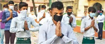  ?? PTI ?? Students pray during morning assembly at a government school after it reopened in Mathura yesterday.