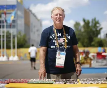  ?? MARTA IWANEK/TORONTO STAR ?? Bud Kling runs the pin trading table at the athletes village. He brought about 600 of his own.