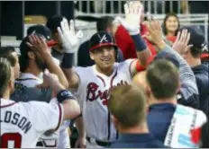  ?? CURTIS COMPTON — ATLANTA JOURNAL-CONSTITUTI­ON VIA AP ?? Braves rookie Austin Riley gets high fives in the dugout after hitting a solo home run against the Cardinals in his major-league debut on Wednesday in Atlanta.