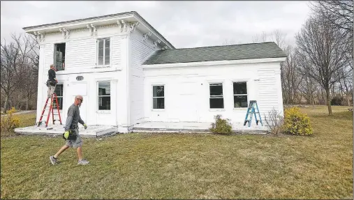  ?? (Detroit Free Press/Eric Seals) ?? Workers for Especially Windows and Remodeling in Highland install new windows at the Banks-Dolbeer-Bradley-Foster Farmhouse in Walled Lake, Mich.