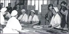  ??  ?? Elizabeth Baker sitting at the canned pea conveyor belt, wearing glasses, Ollie Blunt is standing on the right