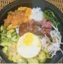  ?? ?? Pork bibimbop, a rice bowl with vegetables and fried egg.
