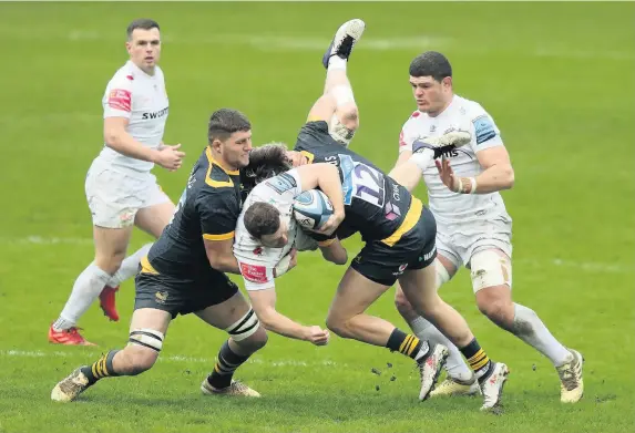  ?? David Rogers/Getty Images ?? > Sam Simmonds of Exeter Chiefs is tackled by Tom Willis (left) and Michael le Bourgeois of Wasps on Saturday