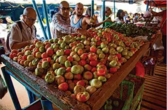  ?? Ismael Francisco/Associated Press ?? Cubans shop for food at a market Friday in Havana. Inflation has risen 40% over the past year and has significan­tly impacted the purchasing power for many across the island nation.