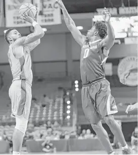  ?? Wilf Thorne ?? Houston’s Devin Davis, left, goes up for a rare 3-pointer in the second half over the outstretch­ed arm of Arkansas’ Jaylen Barford. Davis finished with 28 points.