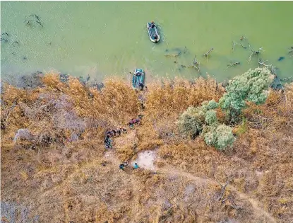  ?? REUTERS ?? Polleros (en las balsas) cruzan por el río Bravo a familias de migrantes rumbo a EU.